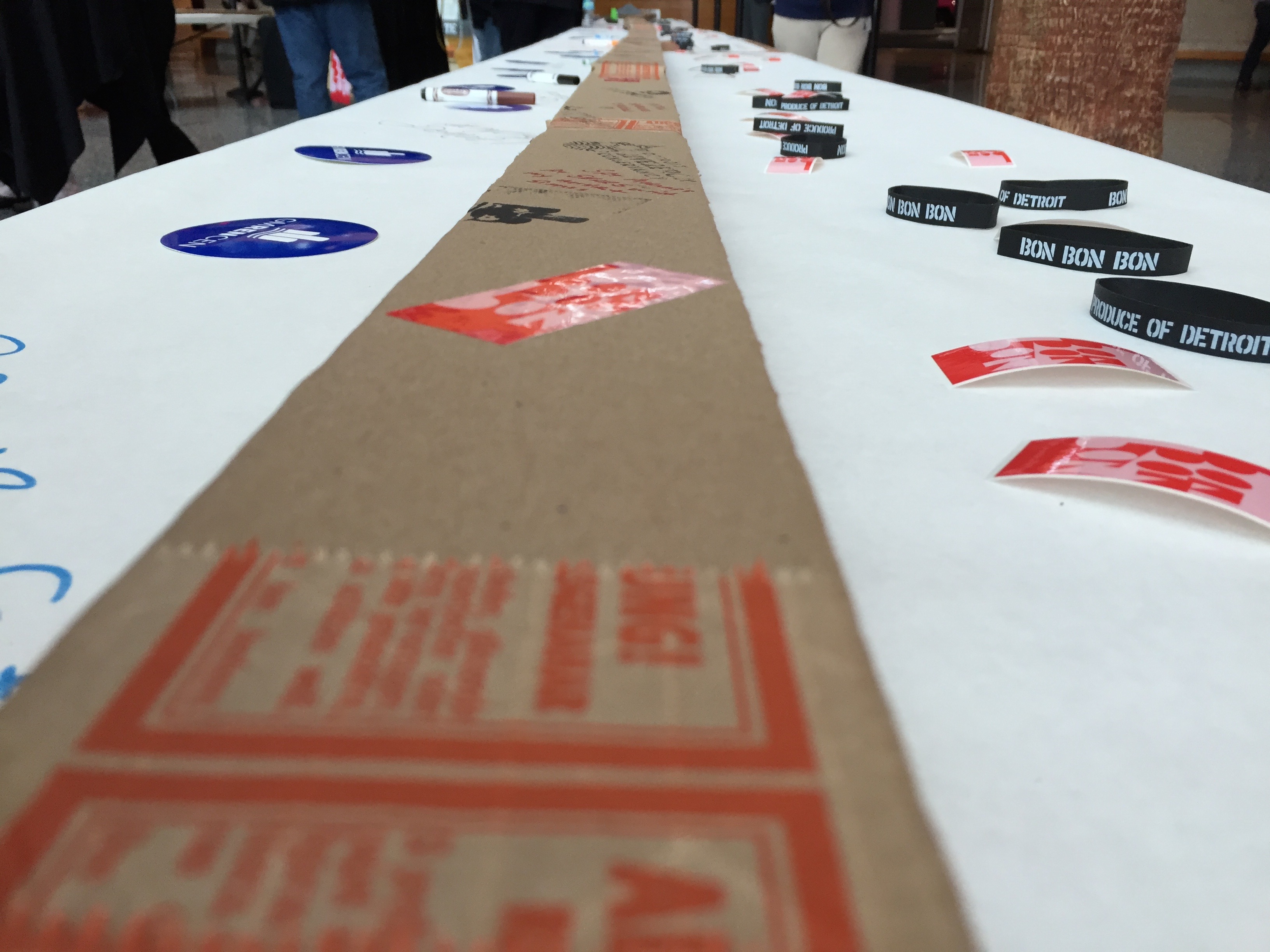 A long card board box on a table with white paper going into the distance