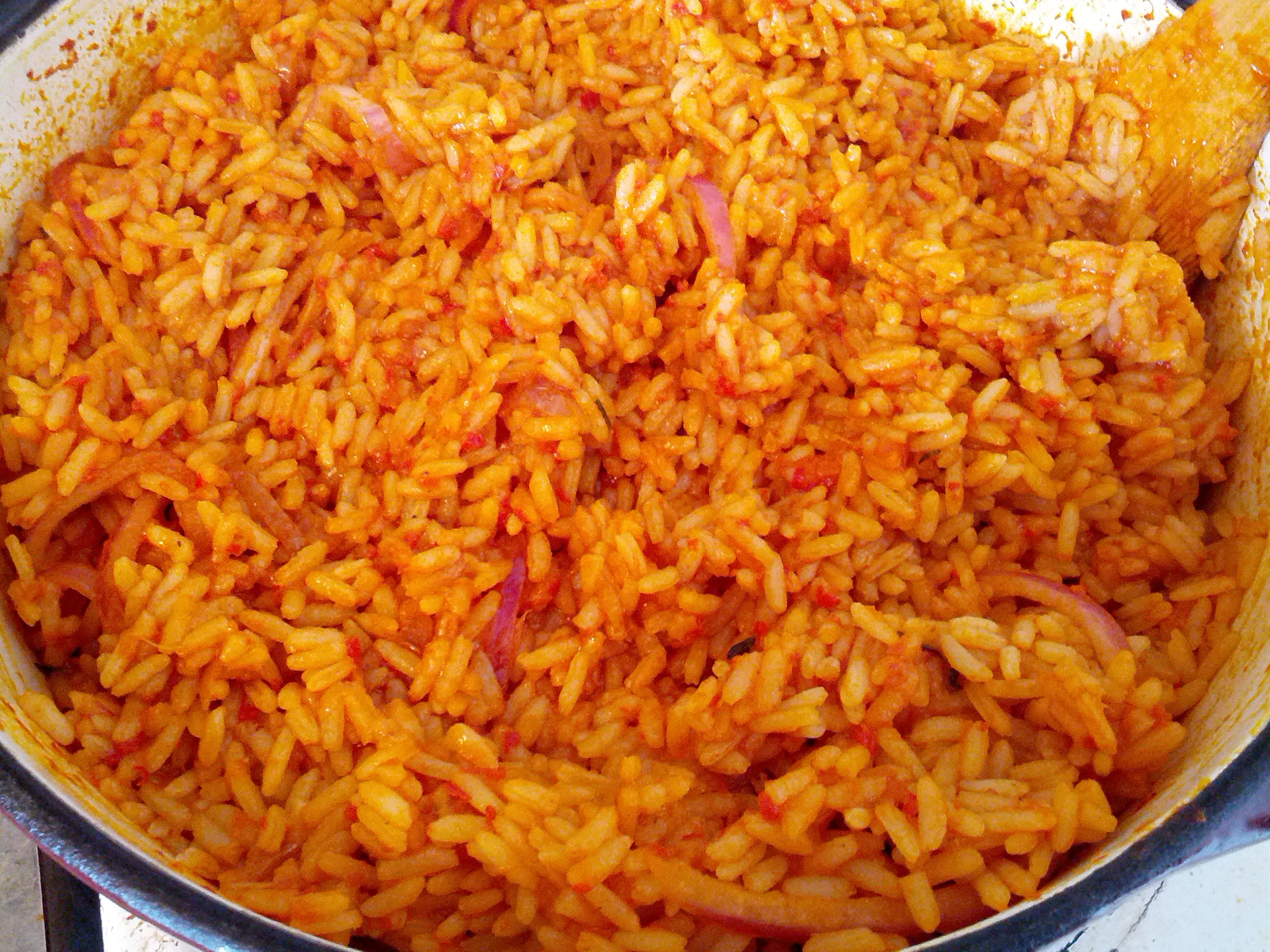 a close up of jollof rice, rice cooked with tomato and thus with a reddish color