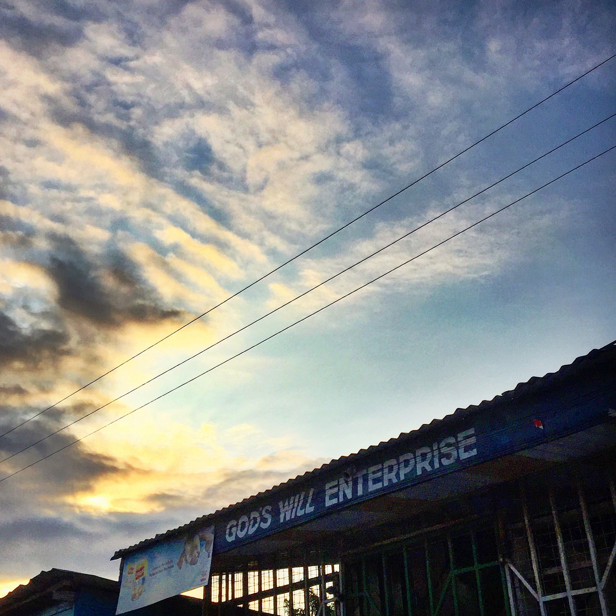 the sign for a shop called god's will enterprise in front of a sunset